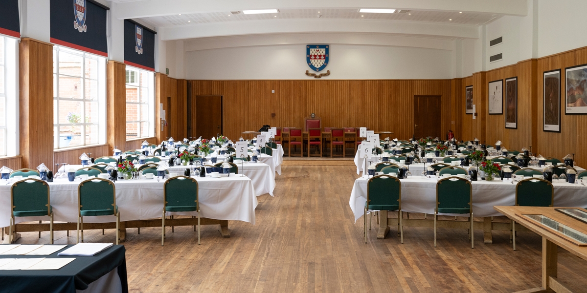 Inside of a school hall with tables for dinner