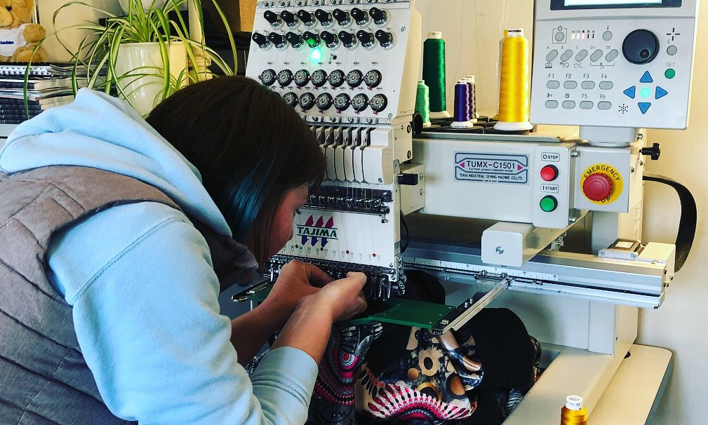 Donna working with embroidery machine in workshop